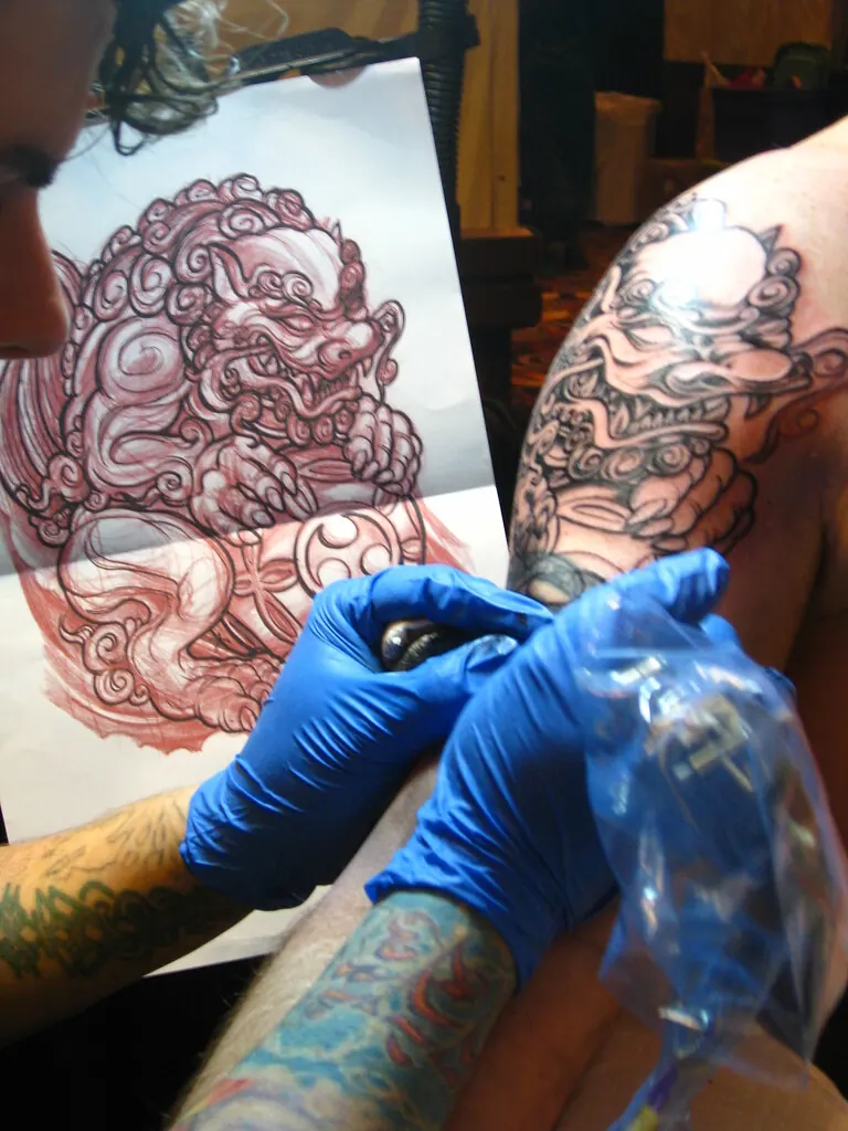 Tattoo artist in gloves at work