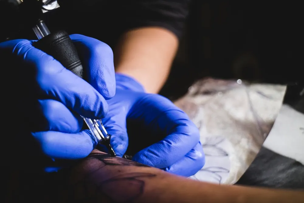 Tattooing with blue gloves
