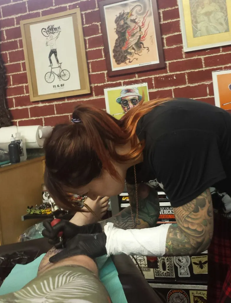 Tattoo artist working on a client