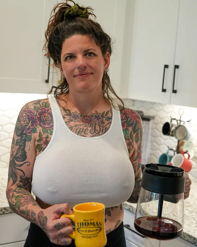 Tattooed woman with a coffee mug